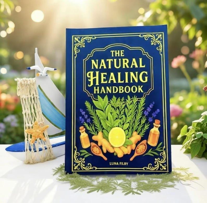 Peut inclure: Un livre &agrave; couverture rigide bleu marine intitul&eacute; "The Natural Healing Handbook" avec des lettres dor&eacute;es. La couverture pr&eacute;sente des illustrations d'herbes, d'huiles essentielles et d'un citron. Un voilier d&eacute;coratif et une &eacute;toile de mer sont en arri&egrave;re-plan.