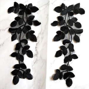 Peut inclure: Deux appliques en dentelle florale noire. Chaque applique présente un motif délicat de feuilles et de vignes. Les feuilles sont finement détaillées, et l'effet global est élégant et adapté à divers projets d'artisanat.