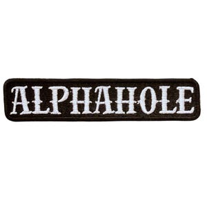 K&ouml;nnte beinhalten: Ein rechteckiger bestickter Aufn&auml;her mit schwarzem Hintergrund und wei&szlig;em Rand. Das Wort ALPHAHOLE ist in wei&szlig;en Gro&szlig;buchstaben in der Mitte des Aufn&auml;hers eingestickt. Der Text zeigt einen fetten Serifenschriftstil mit sauberen, scharfen Kanten.