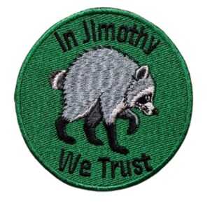 May include: A circular embroidered patch with a green background featuring a grey and black raccoon in the center. The text "In Jimothy" is arched above the raccoon, and the text "We Trust" is arched below, both in black embroidered lettering.