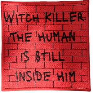 May include: A square, red patch with black text that reads "WITCH KILLER. THE HUMAN IS STILL INSIDE HIM." The patch has a brick wall design.