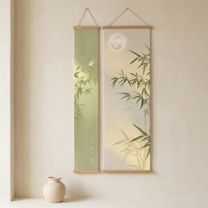 May include: Two vertical wall scrolls with wooden frames featuring green bamboo illustrations, a small bird, a full moon, and Chinese characters. The left scroll is light green, and the right scroll is a pale cream color with textured details.