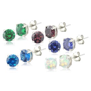 May include: A collection of stud earrings with various colored gemstones. The earrings feature round-cut stones in shades of green, red, blue, and white, set in silver-colored metal. The earrings are displayed against a white background.