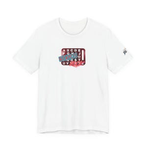 May include: A white short-sleeve t-shirt featuring a central graphic of a dark red rectangular board with white letters of the alphabet. The text BOARDS RICK is printed in blue and red over the board, with a small logo on the right sleeve.