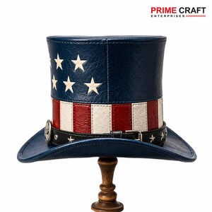 May include: A top hat featuring a blue crown with white stars and a body with red and white vertical stripes. A black leather-like band with silver star studs and a metal buckle encircles the base. The brim is blue, and the text PRIME CRAFT ENTERPRISES appears above.