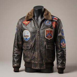May include: A dark brown distressed leather bomber jacket featuring a brown faux fur collar, a front zip fastening, and ribbed cuffs. The jacket is adorned with various embroidered military-style patches, including the USS William M. Standley DLG-32.