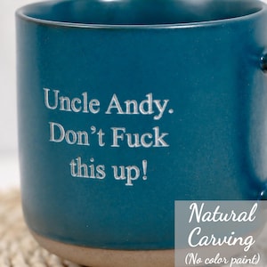 Op de afbeelding: Een diepblauwe keramische mok met een natuurlijke, ongeverfde gravure met de tekst: Uncle Andy. Don't Fuck this up! De mok heeft een glad, mat oppervlak en een contrasterende lichtgekleurde basis, wat het strakke, gegraveerde ontwerp toont.