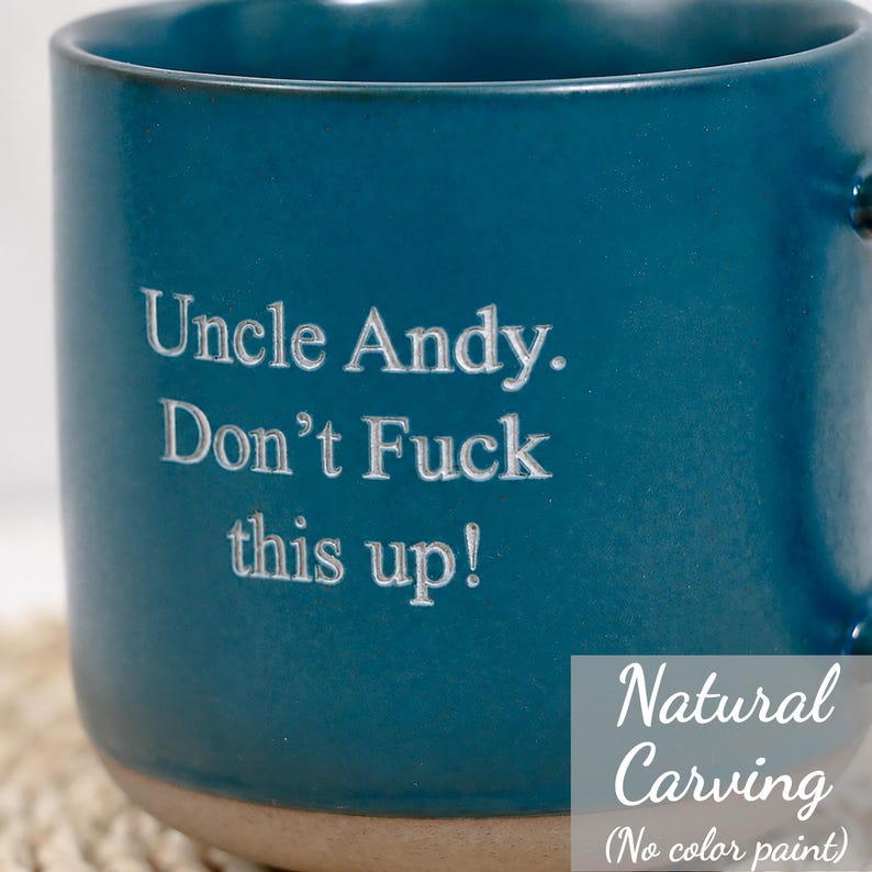 Op de afbeelding: Een diepblauwe keramische mok met een natuurlijke, ongeverfde gravure met de tekst: Uncle Andy. Don't Fuck this up! De mok heeft een glad, mat oppervlak en een contrasterende lichtgekleurde basis, wat het strakke, gegraveerde ontwerp toont.