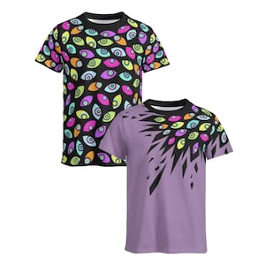 Könnte beinhalten: Zwei kurzärmelige T-Shirts. Das erste ist schwarz mit einem durchgehenden Muster aus bunten Augen in Rosa-, Gelb-, Orange- und Türkistönen. Das zweite ist hellviolett mit einer Ansammlung desselben Augenmusters auf der oberen rechten Seite.