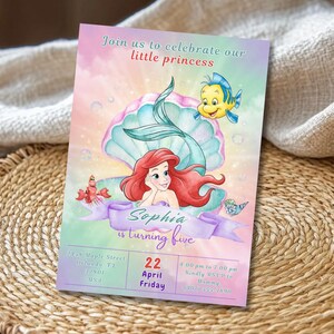 May include: A colorful invitation featuring a mermaid, a seashell, and a yellow fish. The invitation reads "Join us to celebrate our little princess" and "Sophia is turning five". The date is April 22nd.