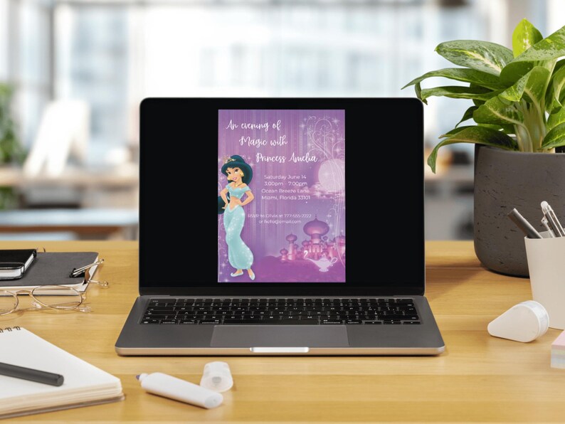 Op de afbeelding: Een laptop toont een paarse uitnodiging met de tekst "An evening of Magic with Princess Amelia". De uitnodiging toont een prinses in een turquoise jurk en een paleis. De laptop staat op een houten bureau.