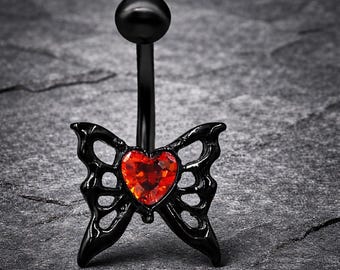 Élégante bague nombril papillon noire avec pierre précieuse coeur rouge sur fond de pierre