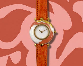 Reloj Certina Ella Swiss Made de diseño artístico: correa de piel naranja, caja dorada.