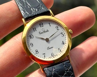 Reloj Later Watch Swiss Made chapado en oro con correa de cuero negro y movimiento de cuarzo.
