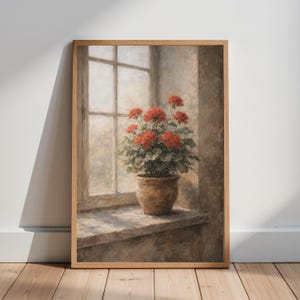 Puede incluir: Pintura enmarcada de una planta de geranio en maceta, con flores rojas vibrantes y follaje verde, colocada en un alféizar. La ventana, con sus múltiples cristales, está bañada por una luz suave, creando una escena interior serena. La maceta es de color marrón cálido.
