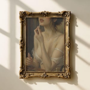 Può includere: Un dipinto incorniciato in stile antico raffigura una donna che si applica il rossetto. L'opera d'arte presenta una cornice dorata ornata e una tavolozza di colori tenui e smorzati. La donna indossa un abito di pizzo bianco. Il dipinto evoca un senso di bellezza ed eleganza classiche.