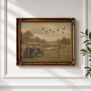 May include: A framed landscape painting in an ornate gold frame depicting a vintage golf cart parked on a grassy course near a pond. A person stands nearby holding a golf club, while a flock of birds flies across a cloudy sky above the trees.