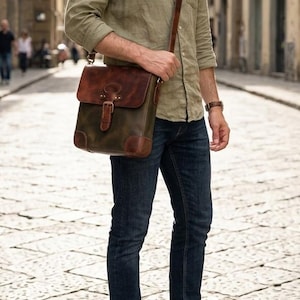 May include: A rectangular leather messenger bag featuring a dark brown flap with a buckle closure, a green body, and reinforced brown leather corners. The bag includes a long, adjustable shoulder strap and is worn across the torso.