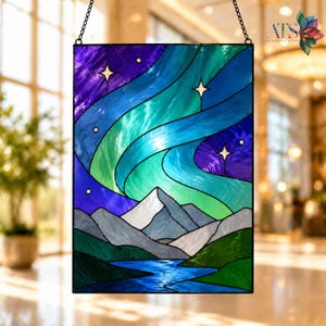 Op de afbeelding: Rechthoekig glas-in-lood paneel met een nachtsc&egrave;ne met het noorderlicht boven bergen en een rivier. Het paneel gebruikt tinten blauw, groen, paars en wit. Het hangt aan een ketting. Het paneel is een decoratief item.