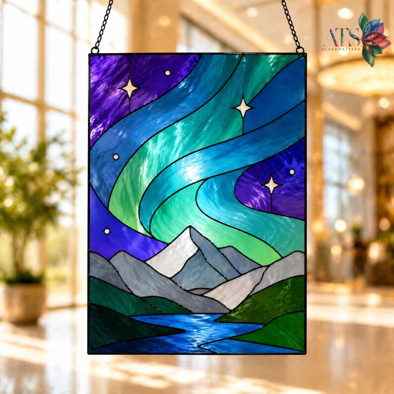 Op de afbeelding: Rechthoekig glas-in-lood paneel met een nachtsc&egrave;ne met het noorderlicht boven bergen en een rivier. Het paneel gebruikt tinten blauw, groen, paars en wit. Het hangt aan een ketting. Het paneel is een decoratief item.