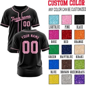 May include: A black baseball jersey with pink glitter accents, featuring the text Team name and 00 on the front, and YOUR NAME and 00 on the back. A color chart displays various glitter options including lightblue, pink, black, rose, red, orange, green, navyblue, khaki, blue, brown, greengrass, yellow, silver, and purple.