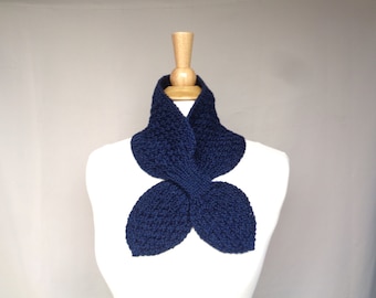 May include: A navy blue knitted scarf with a unique leaf-shaped design. The scarf is displayed on a white mannequin.