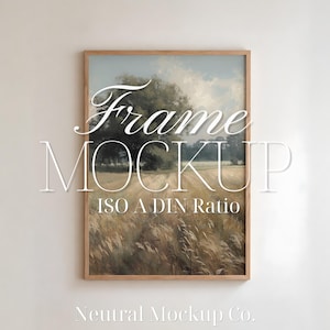 Puede incluir: Una pintura de paisaje enmarcada con un campo de trigo y árboles bajo un cielo nublado. El marco es de madera clara. El texto "Frame Mockup ISO A DIN Ratio" está superpuesto, junto con "Neutral Mockup Co."