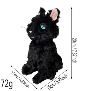 Op de afbeelding: Een zwart pluche kattenspeeltje met helderblauwe ogen, een roze neus en witte tanden. Het speelgoed is 20 cm hoog, 11 cm breed en 15 cm diep, met een totaalgewicht van 72g, zoals aangegeven door de zichtbare tekst en de maataanduidingen.