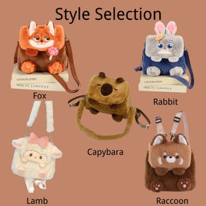 K&ouml;nnte beinhalten: F&uuml;nf Pl&uuml;schtaschen im Tierdesign mit der Aufschrift Style Selection, darunter Fuchs, Hase, Capybara, Lamm und Waschb&auml;r. Jede Tasche zeichnet sich durch weiche, flauschige Texturen, verstellbare Riemen und markante Tiergesichter aus.
