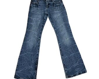 Jeans acampanados con efecto desgastado de diseño exclusivo de marca japonesa.