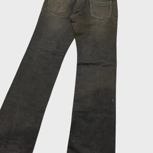 K&ouml;nnte beinhalten: Dunkelgraue Jeans mit klassischem F&uuml;nf-Taschen-Design. Die Jeans hat einen geraden Beinverlauf und ein verwaschenes Aussehen, mit sichtbaren Gebrauchsspuren an den Ges&auml;&szlig;taschen und Knien. Die Jeans wird von hinten gezeigt.