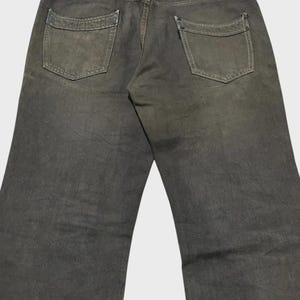 K&ouml;nnte beinhalten: Dunkel olivgr&uuml;ne Jeans mit zwei Ges&auml;&szlig;taschen und einem Lederaufn&auml;her. Die Jeans haben ein klassisches F&uuml;nf-Taschen-Design und eine gerade Beinpassform. Der Denim hat ein abgenutztes, verblasstes Aussehen.