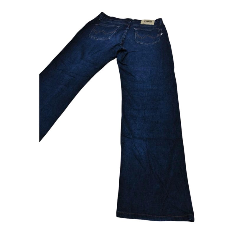 May include: Dark blue denim jeans with a wide leg design. The jeans have two back pockets and a small tag with the brand name "Edwin". The jeans are laid out on a white background.