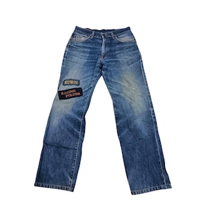 Puede incluir: Vaqueros azules descoloridos con corte recto. Los vaqueros tienen dos parches en la pierna izquierda con el texto "EDWIN" y "RACING FOLDER". Dise&ntilde;o cl&aacute;sico de cinco bolsillos. Aspecto vintage.