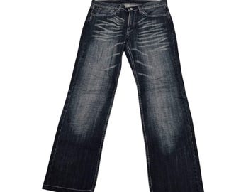 Calça jeans com efeito bigode da marca japonesa Takeo Kikuchi
