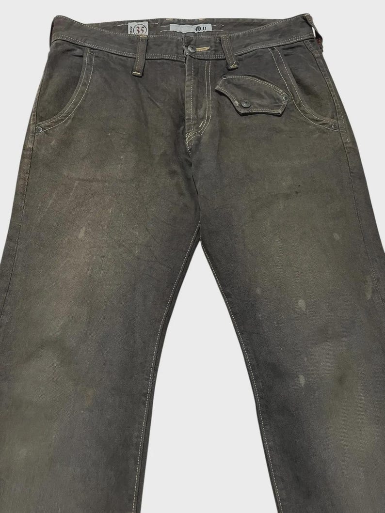 K&ouml;nnte beinhalten: Dunkelgraue Jeans mit wei&szlig;en N&auml;hten. Die Jeans hat einen Knopfverschluss, Vordertaschen und eine kleine Tasche auf der rechten Seite. Die Bundweite betr&auml;gt 89 cm.