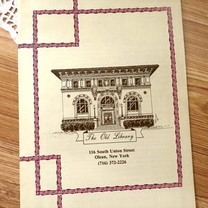 May include: A cream-colored paper document featuring a dark brown line drawing of a building labeled The Old Library. Below the illustration, the text reads 116 South Union Street, Olean, New York, (716) 372-2226. A red geometric border frames the image.