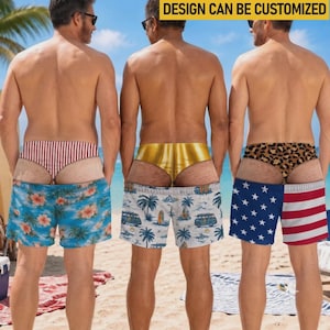 Può includere: Tre costumi da bagno con un design trompe l'oeil che imita l'intimo sottostante. I pantaloncini presentano motivi floreali tropicali, furgoni vintage e la bandiera americana. Il testo "DESIGN CAN BE CUSTOMIZED" è visibile in alto.