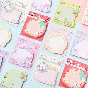 May include: A selection of character-themed sticky notes in various shapes and colours. The notes feature designs of Hello Kitty, Keroppi, and other cartoon characters. Each pad contains 30 sheets and is packaged on a backing card.