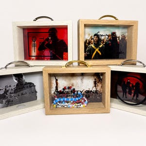 May include: Five shadow box display cases with images and objects inside. The cases have a rectangular shape with a handle on top. The frames are made of wood and have a light color. The images and objects inside vary.
