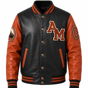Puede incluir: Una chaqueta universitaria negra y naranja con cuerpo de cuero negro y mangas de cuero naranja. El frente muestra las letras AM en aplique de fieltro naranja y crema. Tiene cierre de botones a presión, puños acanalados a rayas y cuello.