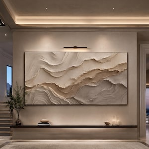 May include: A large rectangular wall art piece featuring thick, textured impasto layers in shades of cream, beige, and soft brown. The abstract composition displays horizontal, wave-like ridges and deep grooves that create a sense of movement.