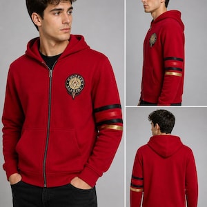 Puede incluir: Sudadera roja con cremallera y un emblema de "Huntrix Academy" en el pecho. Las mangas tienen rayas negras y doradas. La sudadera con capucha tiene una capucha con cordón y un bolsillo delantero.