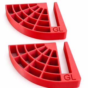 Pode incluir: Dois objetos de plástico vermelhos em forma de cunha, com um padrão de grade e uma alça. As letras "GL" estão impressas na alça. Provavelmente são usados para nivelar ou apoiar.