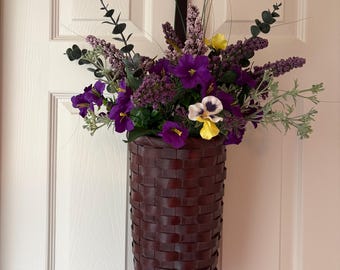 Cesta marrón chocolate con preciosas flores y vegetación.