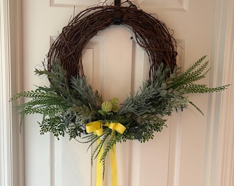 Corona verde puntiaguda, decoración para puerta para todas las estaciones, base de vid, detalle de cinta amarilla.