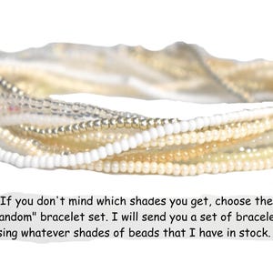 May include: A set of layered bracelets made from small round beads in shades of white, cream, and metallic silver. The text below reads: If you don't mind which shades you get, choose the "Random" bracelet set. I will send you a set of bracelets using whatever shades of beads that I have in stock. :)