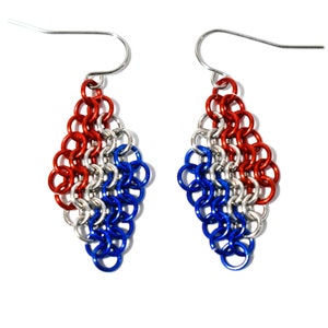 May include: A pair of red, white, and blue chainmail earrings. The earrings are made of metal and have a diamond shape.