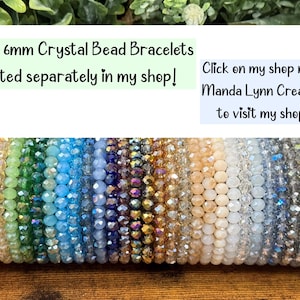 May include: A collection of 6mm crystal bead bracelets in a spectrum of colors including pink, red, green, blue, purple, gold, and black. The text reads: New 6mm Crystal Bead Bracelets listed separately in my shop! Click on my shop name: Manda Lynn Creations to visit my shop. :)