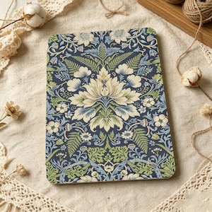 May include: A rectangular notebook featuring a dark blue background with a repeating botanical pattern of cream-colored flowers, light blue petals, and green fern-like leaves. The design covers the entire front surface of the notebook.